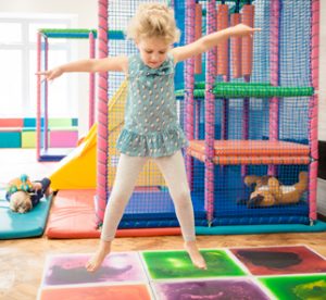 Child jumping on the sensory tiles at the Children's Respite Trust's Charity Day Centre in Sussex