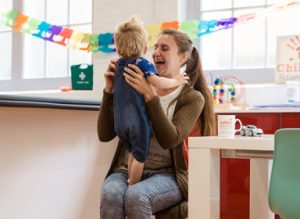 Mum bouncing disabled child on knee at Children's Respite Trust Charity in Sussex